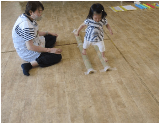 竹の上を歩く園児