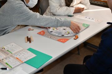 3人の参加者が中央のかりうちキットでかりうちを体験する