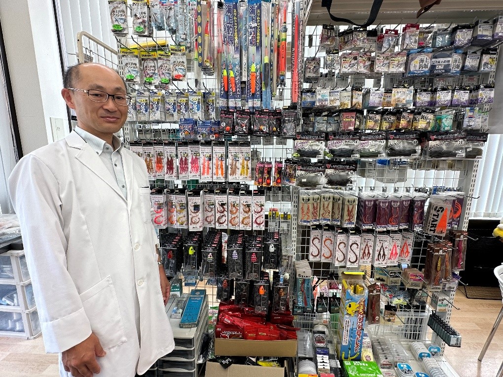 販売している釣り具の前で