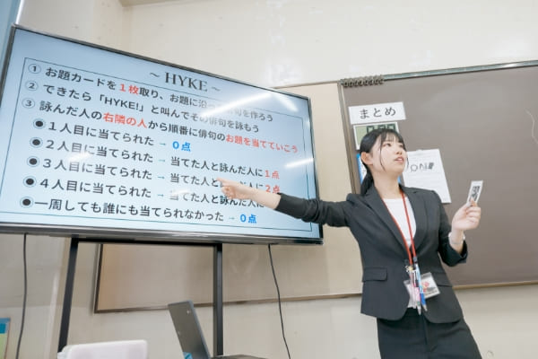 モニターの前で指をさす小学校教諭の写真