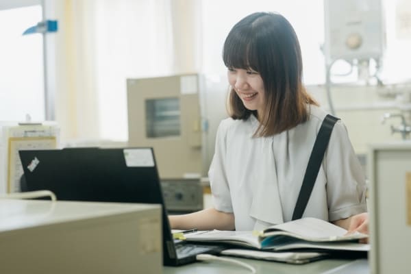 パソコンの前で笑顔の先生の写真