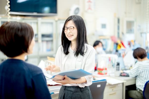 職員と話している学校事務の写真