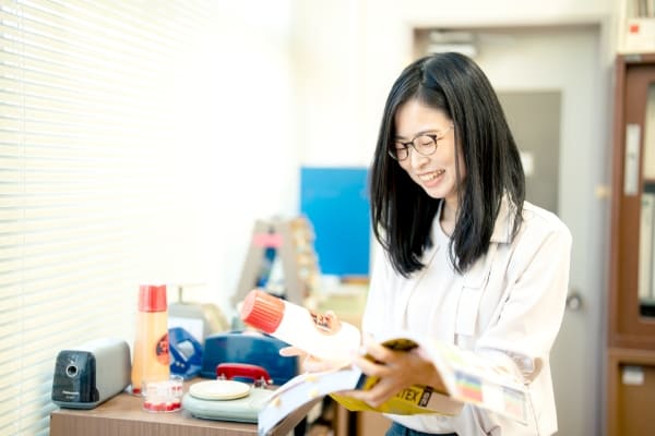 パンフレットをめくる学校事務の写真